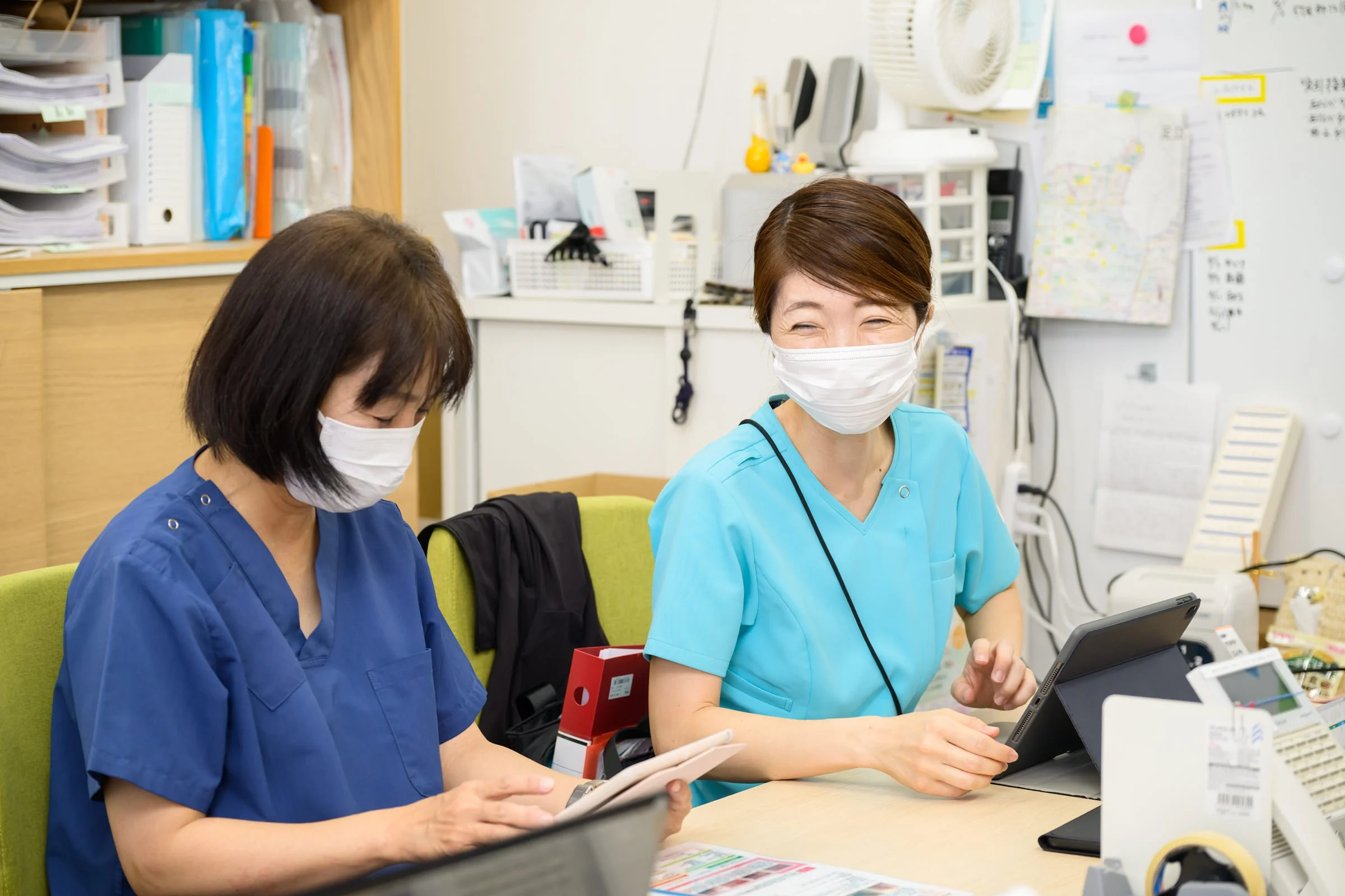 事務所で笑顔を交わすフローレンスのスタッフ