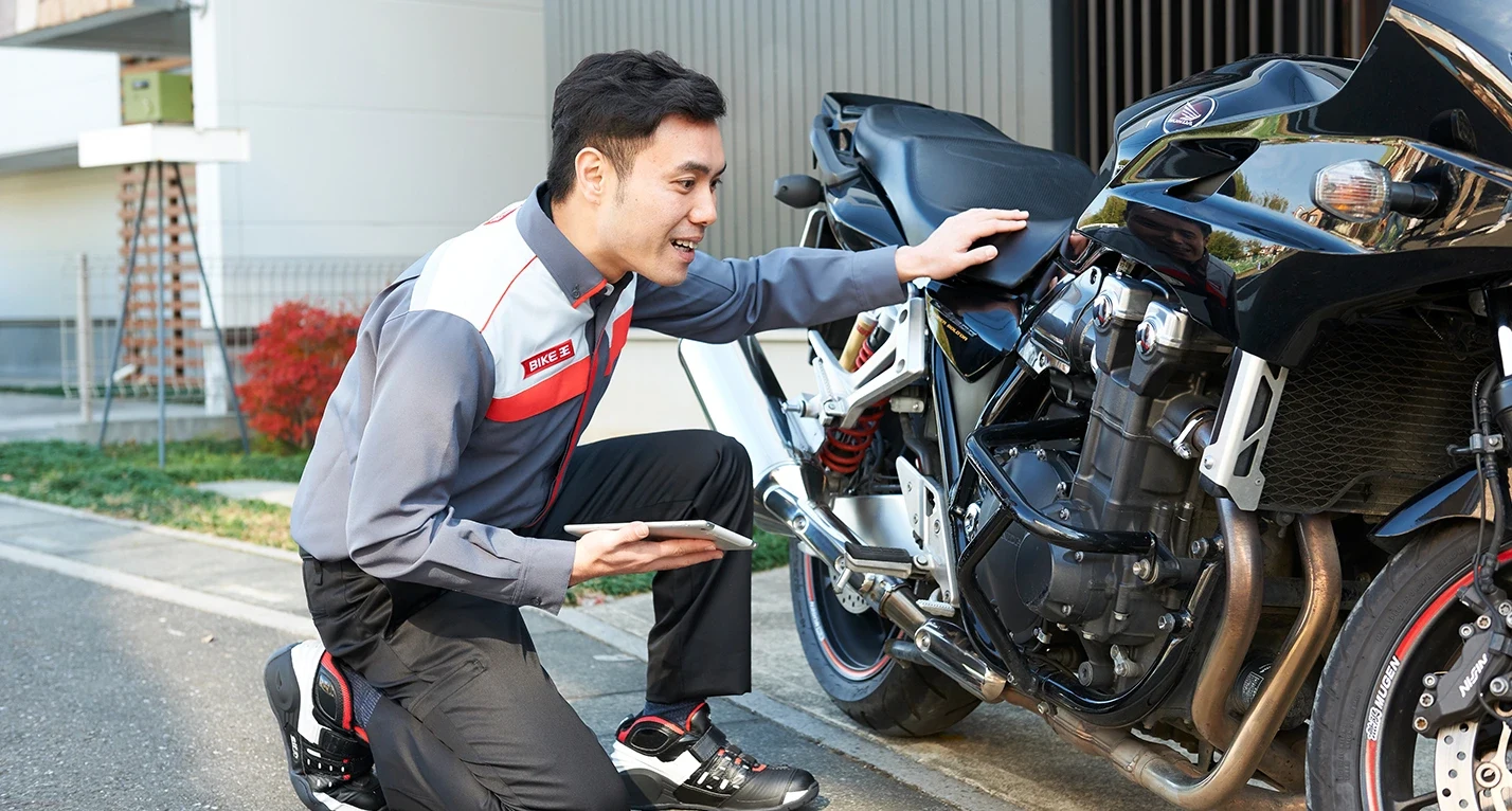 バイク王公式サイトに掲載されたバイクを査定するスタッフ