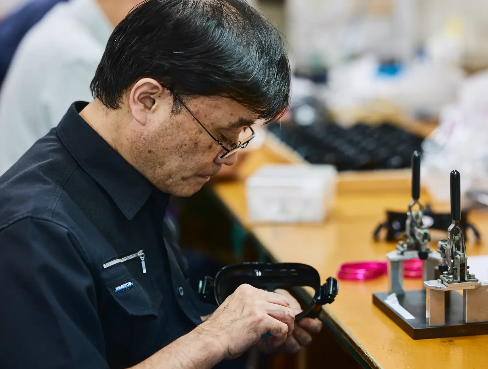 作業台で潜水用マスクを組み立てる作業者