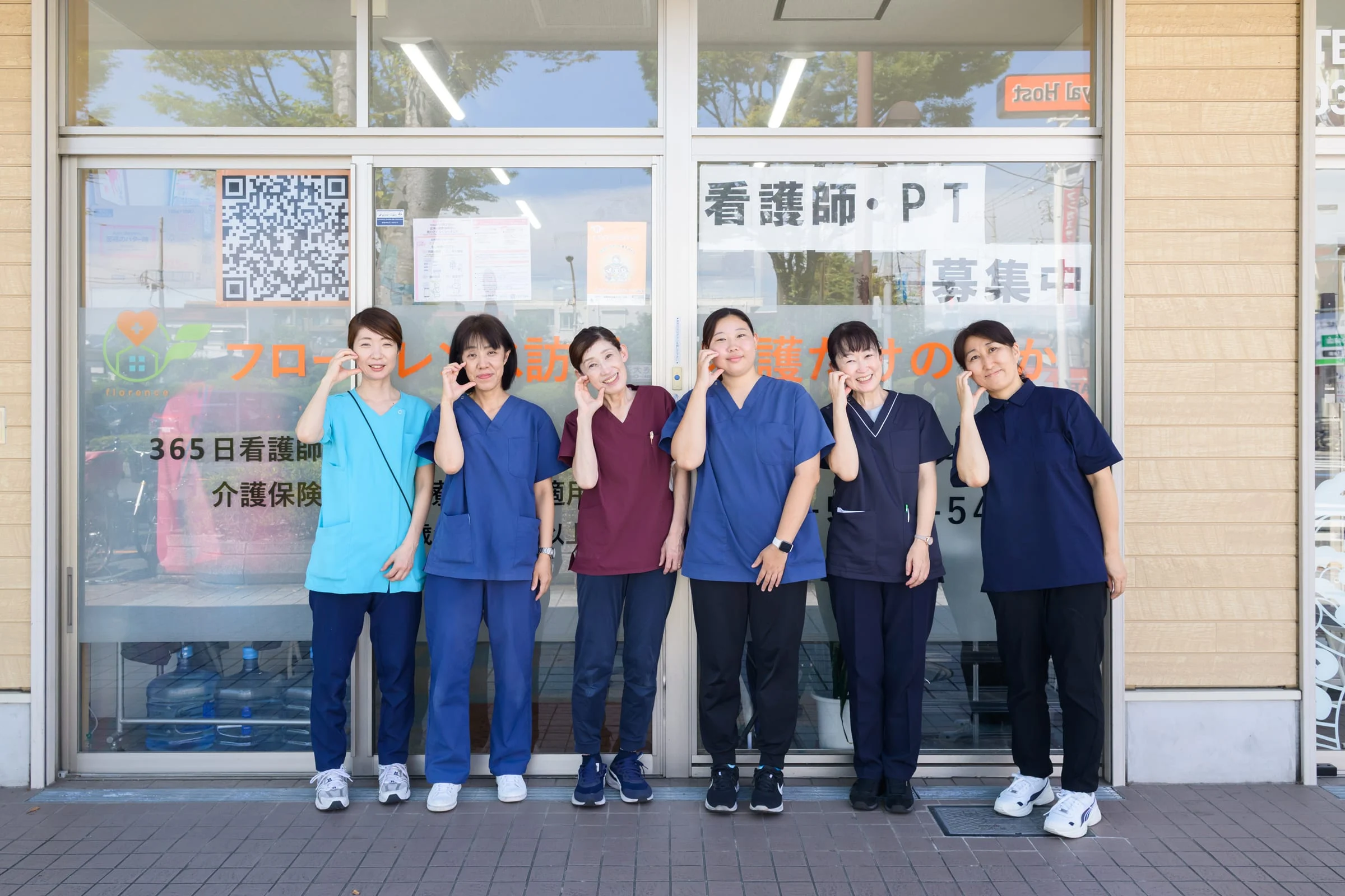 フローレンス訪問看護ステーションの事業所前に集まる6人のスタッフ